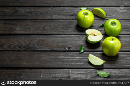 Green apples and Apple slices. On a dark wooden background.. Green apples and Apple slices.