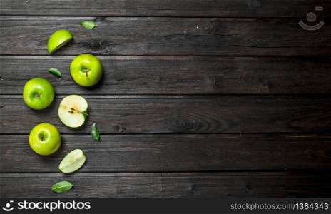 Green apples and Apple slices. On a dark wooden background.. Green apples and Apple slices.