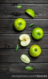 Green apples and Apple slices. On a dark wooden background.. Green apples and Apple slices.