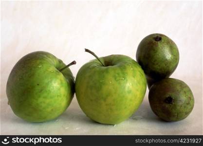 Green apples and pears on painted background