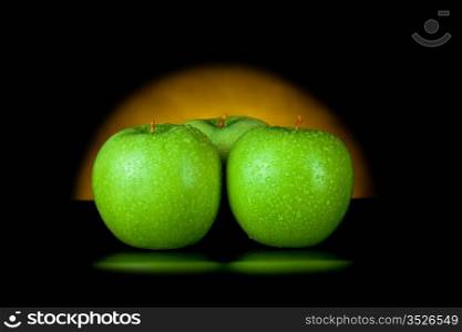 green apples in yellow light isolated on black
