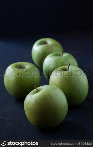Green apples on a black background