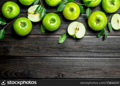Green apples with leaves and Apple slices. On wooden background.. Green apples with leaves and Apple slices.