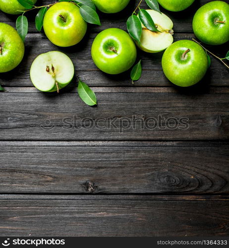 Green apples with leaves and Apple slices. On wooden background.. Green apples with leaves and Apple slices.