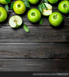 Green apples with leaves and Apple slices. On wooden background.. Green apples with leaves and Apple slices.