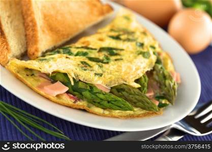 Green asparagus and ham omelet with toast bread (Selective Focus, Focus on the asparagus head in the front). Asparagus and Ham Omelet