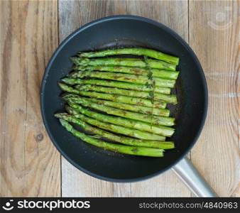 Green asparagus is cooked in frying pan. Green asparagus is cooked in frying pan.