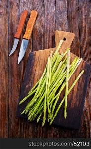 green asparagus on board and on a table