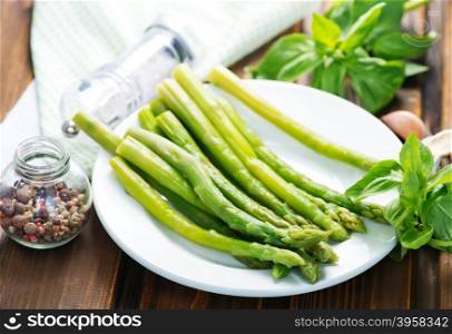 green asparagus on plate and on a table