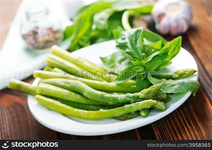 green asparagus on plate and on a table
