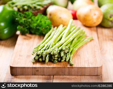 green asparagus on wooden board