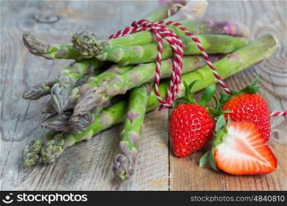 Green asparagus with strawberries on wooden. Green asparagus with strawberries on wooden.
