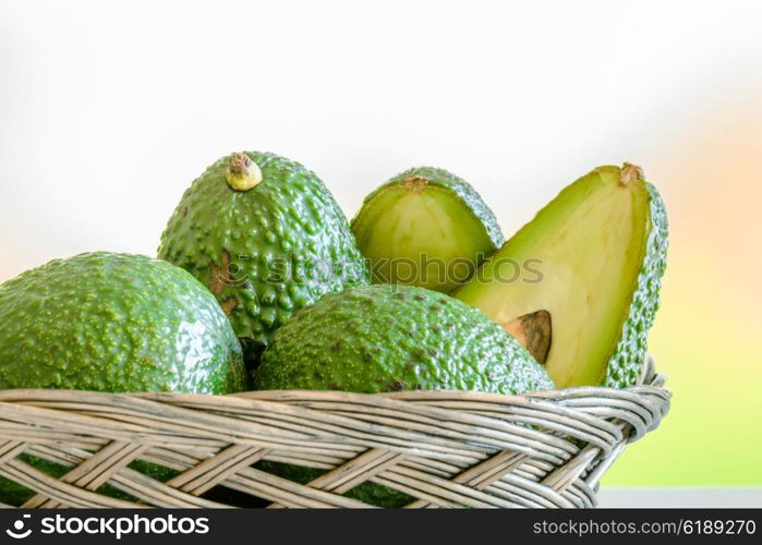 Green avocado stacked in a braided basket