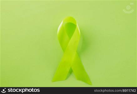 Green awareness ribbon symbol of Gallbladder and Bile Duct Cancer month isolated on green background with copy space, concept of medical and health care support, Cancer awareness, World bipolar day