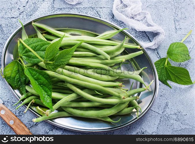 green beans on metal plate and on a table