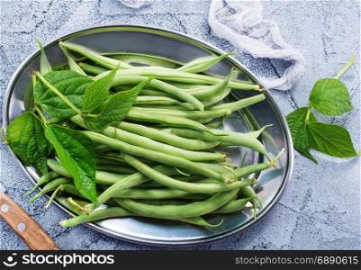 green beans on metal plate and on a table