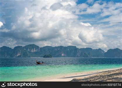 green beautiful mountains on the horizon, wooden traditional boat in the Andaman Sea