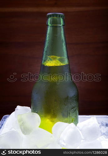 green beer bottle freezing in ice tank for beverage theme. green beer bottle freezing in ice tank