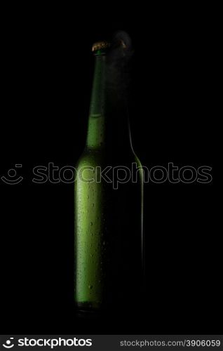 Green beer bottle with drops and open cup on black
