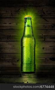 Green beer bottle with water drops isolated on wooden background