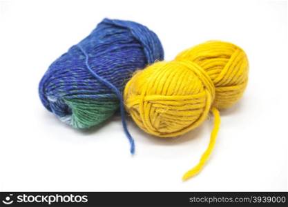 Green blue and yellow ball of wool yarn for knitting close up on a white background. Green blue and yellow ball of wool yarn for knitting close up on a white background.