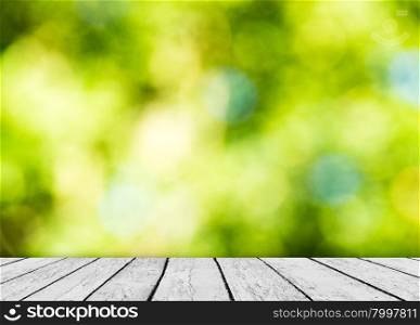 Green bokeh and sunlight and wood floor. Beauty natural background