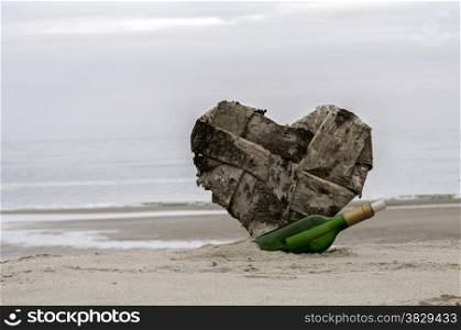 green bottle post and a lost heart on the beach