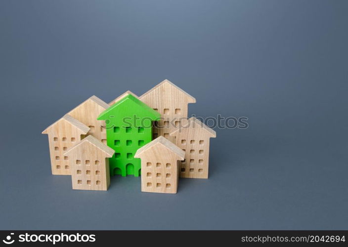 Green building stands out among the houses. Search for the best option. Net Zero Carbon neutrality. Environmentally friendly, energy efficient and zero carbon emissions. Ideal property to buy.