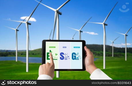 Green business transformation for environment saving and ESG business concept. Businessman using tablet to set corporate goal toward environmental friendly management and alternative clean energy use.. Green business transformation for environment saving and ESG business concept