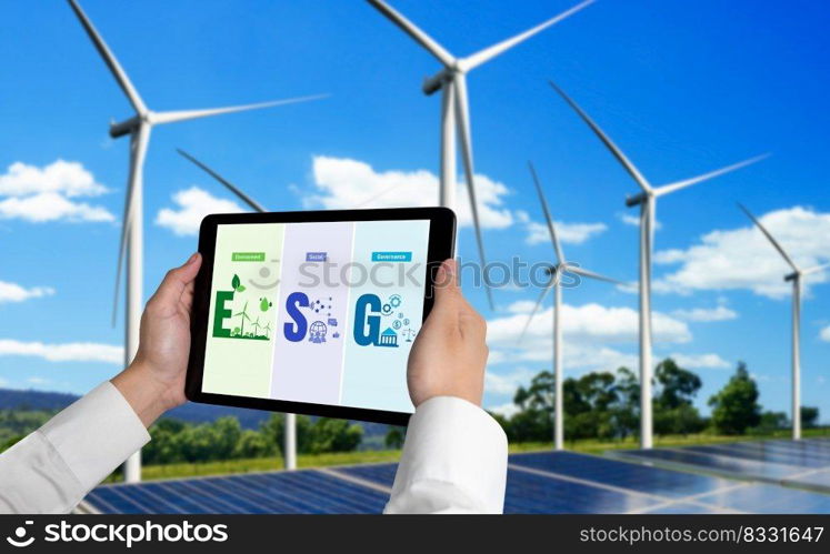 Green business transformation for environment saving and ESG business concept. Businessman using tablet to set corporate goal toward environmental friendly management and alternative clean energy use.. Green business transformation for environment saving and ESG business concept