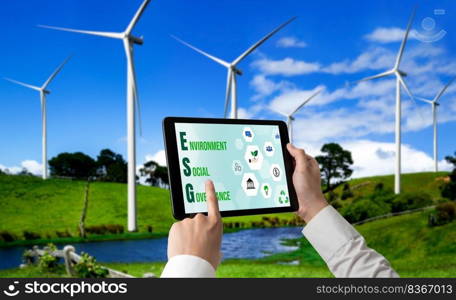 Green business transformation for environment saving and ESG business concept. Businessman using tablet to set corporate goal toward environmental friendly management and alternative clean energy use.. Green business transformation for environment saving and ESG business concept