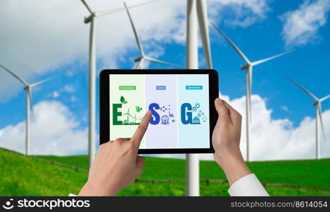 Green business transformation for environment saving and ESG business concept. Businessman using tablet to set corporate goal toward environmental friendly management and alternative clean energy use.. Green business transformation for environment saving and ESG business concept