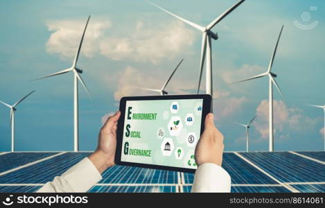 Green business transformation for environment saving and ESG business concept. Businessman using tablet to set corporate goal toward environmental friendly management and alternative clean energy use.. Green business transformation for environment saving and ESG business concept