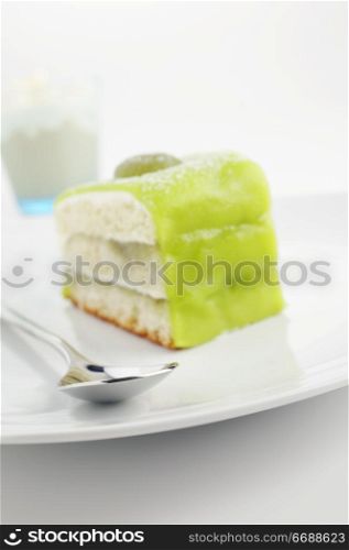 Green cake on the plate with frappucino on background