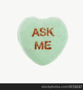 Green candy heart that reads ask me against white background.