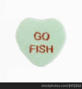 Green candy heart that reads go fish against white background.