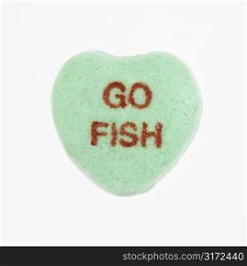 Green candy heart that reads go fish against white background.
