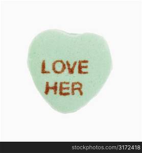 Green candy heart that reads love her against white background.