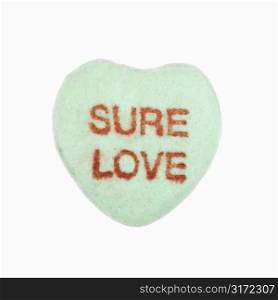 Green candy heart that reads sure love against white background.