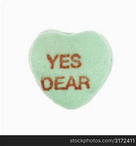 Green candy heart that reads yes dear against white background.