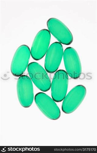 Green capsule pills against white background.