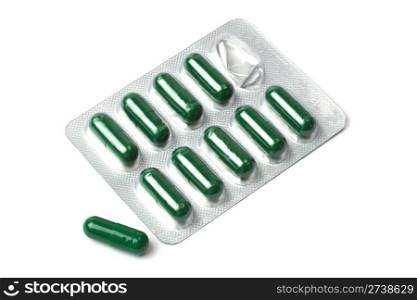 Green capsules packed in blister isolated on white