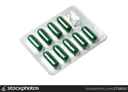Green capsules packed in blister isolated on white