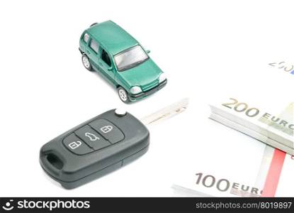 Green car, black car keys and euro banknotes on white