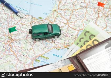green car, wallet and pen on the map of Europe