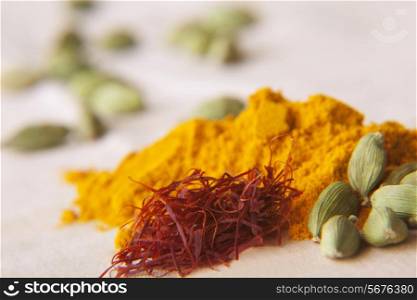 Green cardamom pods, saffron and turmeric powder