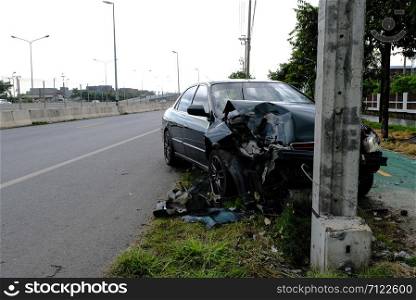 Green cars drive with negligence quickly. And collided with the electric pole until it was damaged,Car accident and waiting to be done from insurance to take care of the damage.