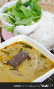 green chicken curry served with rice vermicelli and fresh vegetable