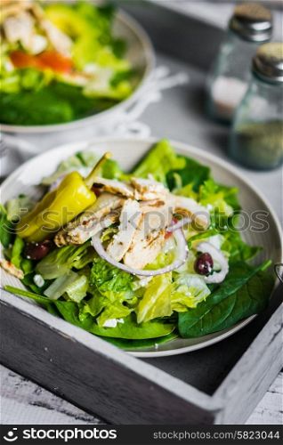 Green chicken salad on wooden background