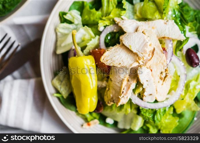 Green chicken salad on wooden background